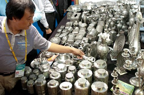 10月20日,參觀者在選購(gòu)菲律賓錫器。當(dāng)日,中國(guó)—東盟博覽會(huì)在廣西南寧市國(guó)際會(huì)展中心開幕,東盟國(guó)家參展的首飾、玩具、鐘表等小商品引得觀眾駐足。 新華社記者 翁忻旸 攝