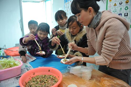 2月7日,志愿者帶領(lǐng)農(nóng)民工子女在貴州省“意氣風(fēng)發(fā)紅十字會”的流動兒童活動中心內(nèi)包餃子。當(dāng)日,在貴州省“意氣風(fēng)發(fā)紅十字會”的流動兒童活動中心內(nèi),10余名農(nóng)民工子弟小學(xué)的學(xué)生在紅十字會志愿者的帶領(lǐng)下,寫春聯(lián)、包餃子,迎接春節(jié)。新華社記者 歐東衢 攝