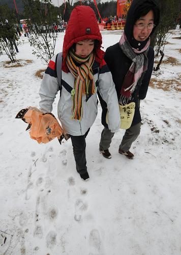 2月11日,兩位南京市民踏雪而行。當日,南京出現(xiàn)降雪和低溫冰凍天氣,江蘇省氣象臺發(fā)布道路結(jié)冰橙色預(yù)警。目前,因路面積雪結(jié)冰,南京周邊高速公路封閉,長途車站大批旅客滯留。新華社記者 孫參 攝