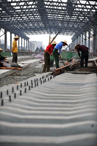 4月2日,工作人員在鋪軌。記者近日從負(fù)責(zé)海南東環(huán)鐵路建設(shè)的中鐵十七局獲悉,東環(huán)鐵路??诙螣o砟雙軌鋪設(shè)工作將于4月底完工,計劃5月30日前完成東環(huán)鐵路的全線鋪軌任務(wù),預(yù)計10月份將開始試運行。東環(huán)鐵路是海南省與鐵道部聯(lián)合投資的城際軌道交通工程,2007年9月開工,線路全長308公里,總投資達(dá)202億元。建成后,海口至三亞僅需90分鐘。新華社記者 郭程 攝