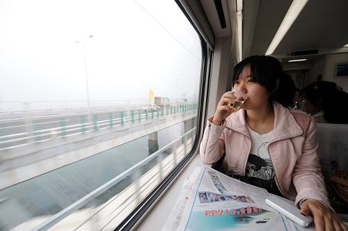 4月26日,在福廈鐵路運(yùn)行的首趟和諧號(hào)動(dòng)車上,一位乘客在欣賞沿途風(fēng)景。當(dāng)日,總投資152.59億元、全長(zhǎng)274.9公里的福(州)廈(門)高速鐵路正式開通運(yùn)營(yíng)。這條鐵路的通車運(yùn)營(yíng),使福廈之間鐵路運(yùn)行時(shí)間從原來中轉(zhuǎn)繞行所需的11個(gè)小時(shí)縮短到目前的1.5個(gè)小時(shí)。新華社記者 張國(guó)俊 攝