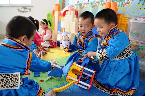 5月6日,內(nèi)蒙古自治區(qū)鄂爾多斯市伊金霍洛旗霍洛鎮(zhèn)幼兒園的孩子巴特(右一)和小朋友們一起上手工勞動(dòng)課。從2010年開(kāi)始,內(nèi)蒙古鄂爾多斯市在落實(shí)國(guó)家確保義務(wù)教育經(jīng)費(fèi)機(jī)制的前提下,對(duì)全市的蒙古族學(xué)生3年幼兒園、6年小學(xué)、6年中學(xué)直至4年大學(xué)本科畢業(yè),實(shí)行19年的免費(fèi)教育。目前鄂爾多斯市除了對(duì)幼兒園的蒙古語(yǔ)授課幼兒每人每月免除240元的保教費(fèi)、讀物費(fèi)外,還每月補(bǔ)助120元伙食費(fèi);對(duì)中學(xué)生除“兩免一補(bǔ)”外,每年還補(bǔ)助200元交通費(fèi),并且減免中考、高考考務(wù)費(fèi);對(duì)考取??啤⑵胀ū究坪蛧?guó)家重點(diǎn)本科院校的蒙古族學(xué)生,每人每年分別提供3000元、5000元和7000元的補(bǔ)助費(fèi)。新華社記者 張領(lǐng) 攝