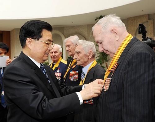 5月8日,中國國家主席胡錦濤在莫斯科會(huì)見曾參加中國人民抗日戰(zhàn)爭東北戰(zhàn)場戰(zhàn)斗的俄羅斯老戰(zhàn)士代表。這是胡錦濤為老戰(zhàn)士頒發(fā)和平獎(jiǎng)?wù)?。新華社記者 饒愛民 攝