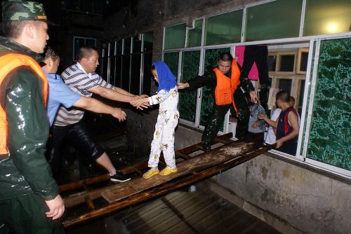 7月10日凌晨,道真縣公安干警、民兵應急分隊在營救受困群眾。新華社發(fā)(韓克超攝)