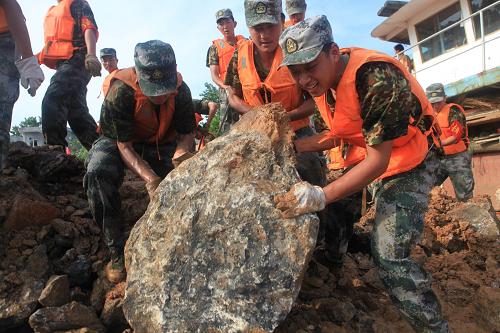 7月19日,解放軍戰(zhàn)士將巨石推入長江。新華社發(fā)(李濤淵 攝)
