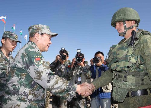9月24日,在哈薩克斯坦馬特布拉克訓(xùn)練場,中國國務(wù)委員兼國防部長梁光烈(前左)為俄羅斯士兵頒發(fā)勛章。新華社記者王建民攝