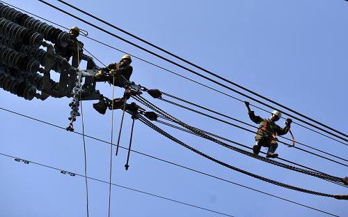 11月16日,工人在三峽右岸蘭陵溪水域電塔架設(shè)過江電纜。新華社發(fā)(鄭家裕 攝)