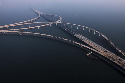 這是2010年11月18日航拍的建設中的青島海灣大橋。12月22日,青島海灣大橋主線合龍貫通,這標志著大橋一期主體工程基本結(jié)束。由山東高速集團投資建設的青島海灣大橋,是我國北方冰凍海域首座特大型橋梁集群工程,也是青島至蘭州高速公路的起點段,是青島市規(guī)劃的東西跨海通道“一路、一橋、一隧”中的“一橋”。建成后的青島海灣大橋全長超過41.58公里,通車后,青島至黃島的路程就此縮短近30公里,比目前走膠州灣高速節(jié)省時間20分鐘。新華社發(fā)(鄢潤波 攝)