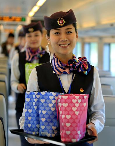12月26日,列車乘務(wù)員在為乘客發(fā)放禮品。新華社記者 郭程 攝