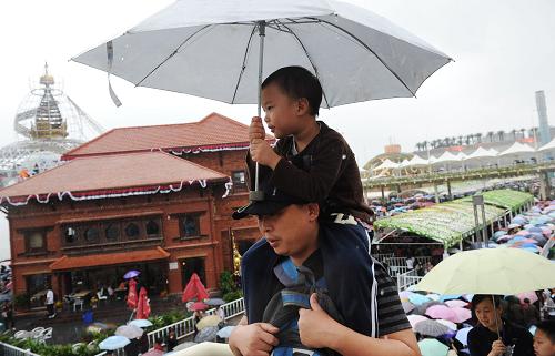 10月23日,一位家長帶著小孩冒雨在世博園內(nèi)參觀。新華社記者李健攝
