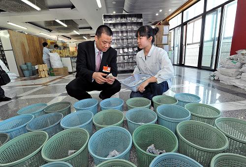 3月9日,全國人大代表馬興田(左)向廣安門醫(yī)院醫(yī)護人員了解中藥小包裝相關(guān)情況。新華社記者 何俊昌攝