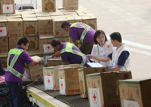 8月17日,工人在天津?yàn)I海國際機(jī)場搬運(yùn)救援物資。新華社記者 邢廣利 攝