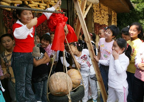 9月30日,南通市港閘區(qū)鶴濤小學(xué)一名小學(xué)生在“農(nóng)家樂”樂園用大秤稱剛摘下的南瓜。