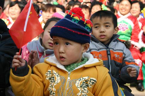 1月29日,一名小朋友手舞國旗在略陽廣場為演員加油。當(dāng)日,來自文化部春節(jié)慰問團(tuán)的26名演員到陜西略陽災(zāi)區(qū)慰問。藝術(shù)家們在廣場、火車站為災(zāi)區(qū)群眾演出獨(dú)唱、相聲、小品、口技等豐富多彩的節(jié)目。 新華社記者都紅剛攝