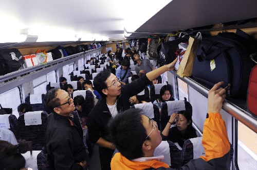 10月4日,幾名旅客在青島火車(chē)站上車(chē)后整理行李。新華社記者 李紫恒 攝