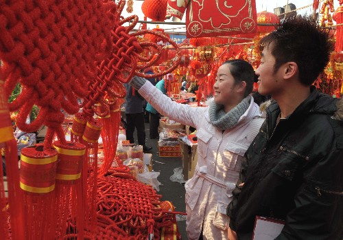 2月5日,兩位市民在烏魯木齊一年貨市場(chǎng)選購“中國結(jié)”。 新華社記者 趙戈 攝
