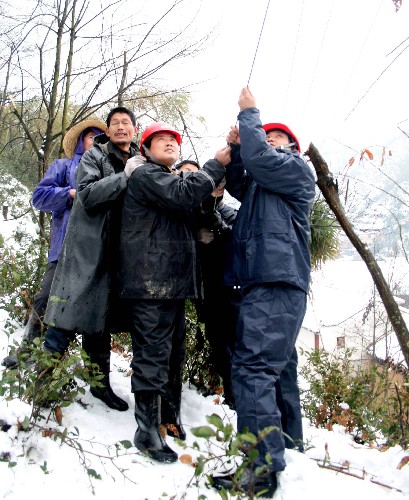 2月5日,婺源縣供電公司工作人員在地處贛浙皖邊界的一個(gè)山村搶修供電線路。 新華社發(fā)(王國(guó)紅 攝)