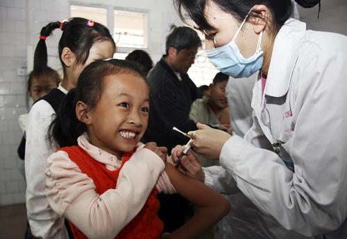 11月4日,醫(yī)護人員為桂林樂群小學的學生接種甲型H1N1流感疫苗。新華社發(fā)(李凱 攝)