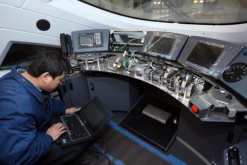 一名技術(shù)人員在調(diào)試動車組牽引車系統(tǒng)(12月9日攝)。新華社記者 高學(xué)余攝