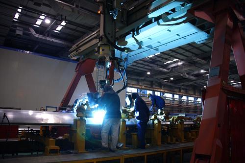 工人利用大型機(jī)械焊接動車組車體部件(12月9日攝)。新華社記者 高學(xué)余攝