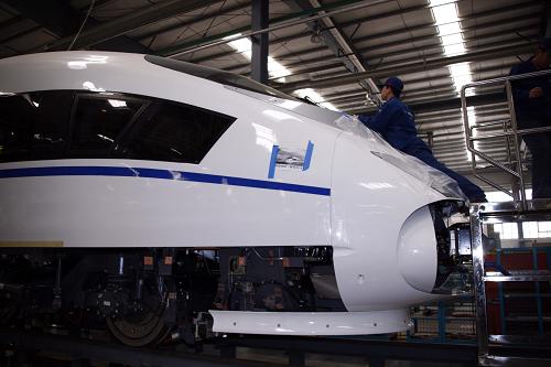 一名工人正在安裝動車組牽引車部件(12月9日攝)。新華社記者 高學(xué)余攝