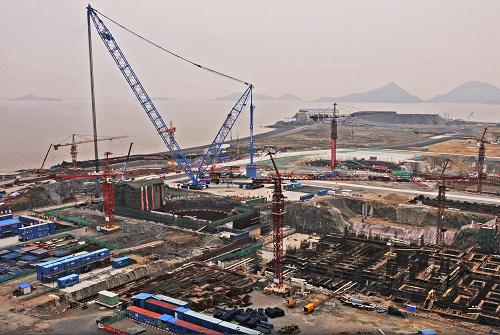 中核集團(tuán)公司三門核電工程一期工程施工現(xiàn)場(chǎng)(12月14日攝)。12月15日,中國(guó)首個(gè)第三代核電自主化依托項(xiàng)目——中核集團(tuán)公司三門核電工程一期工程2號(hào)機(jī)組核島正式開工建設(shè)。這標(biāo)志著全球首座AP1000核電站建設(shè)進(jìn)入全面施工階段。作為中美能源合作建設(shè)最大項(xiàng)目的三門核電工程一期工程總投資400多億元,在全球率先運(yùn)用美國(guó)西屋公司開發(fā)的可提高核電站安全性和經(jīng)濟(jì)性的第三代壓水堆核電(AP1000)技術(shù),一期工程安裝2臺(tái)125萬千瓦AP1000機(jī)組,計(jì)劃于2013年和2014年先后建成發(fā)電。新華社記者 譚進(jìn) 攝