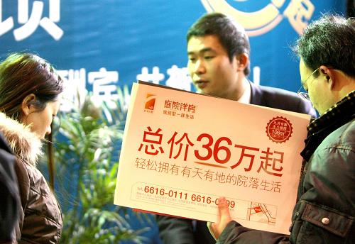 2009年1月24日,在江蘇省蘇州市首屆迎新春購房節(jié)上,一名工作人員手持促銷牌推介樓盤。年初之際,開發(fā)商投之以優(yōu)惠,消費(fèi)者報(bào)之以觀望,面對(duì)尚不明朗的樓市,“猶豫”是消費(fèi)者的普遍心態(tài)。