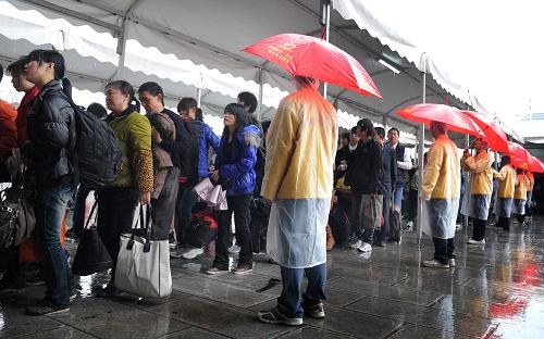 2月7日,在廣州火車站,志愿者在雨中列隊引導旅客進站。當日,廣州大雨,廣州火車站工作人員、志愿者冒雨引導旅客進站、為旅客提供服務,繁忙的廣州火車站有條不紊。預計廣州火車站7日將發(fā)送旅客23萬人次,超過去年最高峰日發(fā)送22.5萬人次水平。截至2月6日,春運8天時間,廣鐵累計發(fā)送旅客518萬人次,開行臨時旅客列車595列。新華社記者 盧漢欣 攝