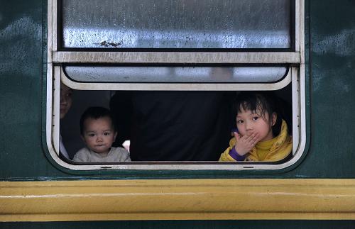 2月7日,在廣州火車站,已登上列車的兩位小朋友向車窗外張望。新華社記者 盧漢欣 攝