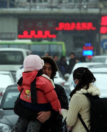 2月7日,在哈爾濱火車(chē)站,一家三口準(zhǔn)備踏上回鄉(xiāng)的路。新華社記者王松攝