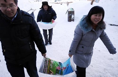 新疆富蘊縣委干部將生活必需品送進風雪嚴寒中的可可托海鎮(zhèn)牧民家中(1月20日攝)。去年入冬以來,特別是進入2010年1月后,新疆北部大雪成災,60年一遇的風雪嚴寒給當?shù)馗髯迦罕娚詈湍翗I(yè)生產帶來了很大困難。新疆各級黨政部門調動一切力量抗災救災,一車車草料,一筆筆捐款,一件件御寒衣物和來自四面八方社會各界的關懷,匯聚成消融冰雪的“暖流”,涌向了災區(qū)。一方有難,八方支援,集中力量辦大事,將損失降至最低……社會主義制度的優(yōu)越性、政府的凝聚力和向心力在抗御風雪嚴寒中充分體現(xiàn)。新華社記者 沈橋 攝