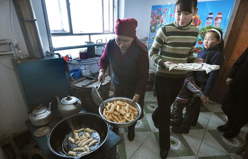 新疆福??h一戶哈薩克族牧民在溫暖的家中制作傳統(tǒng)食品——包爾薩克(1月22日攝)。新華社記者 沈橋 攝