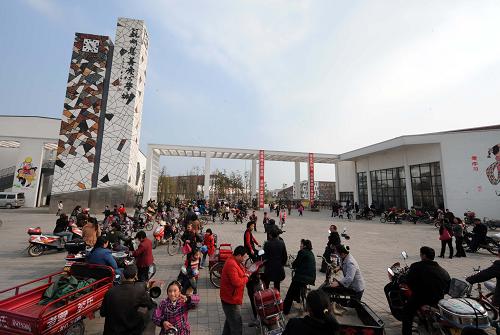 在江蘇省蘇州市援建的綿竹市孝德小學(xué)大門外,家長(zhǎng)們等待接孩子放學(xué)(攝于3月16日)。新華社記者陳燮攝