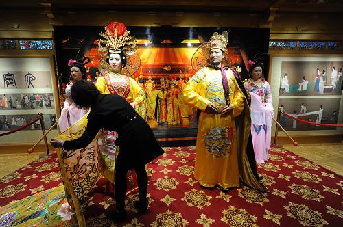 4月20日,一名工作人員在上海世博園區(qū)中國(guó)館陜西展區(qū)整理蠟像服飾。新華社發(fā)(鄭憲章 攝)