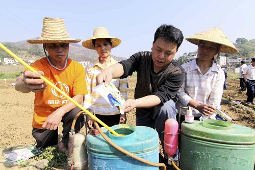 4月20日,在廣西百色市隆林各族自治縣者浪村,農(nóng)業(yè)技術(shù)員(右二)指導(dǎo)農(nóng)民進行水稻旱育秧苗床消毒配藥。新華社發(fā)(林斌 攝)