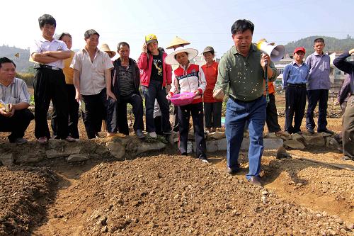 4月20日,在廣西百色市隆林各族自治縣者浪村,農(nóng)業(yè)技術(shù)員(前)為農(nóng)民現(xiàn)場傳授水稻旱育秧苗床播種技術(shù)。新華社發(fā)(林斌 攝)