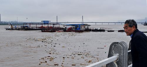 4月21日,一位長(zhǎng)沙市民在湘江邊觀看不斷上漲的水位。新華社記者 龍弘濤 攝