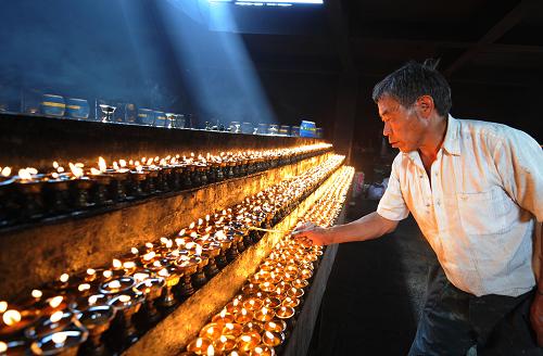 4月21日,一名拉薩市民在大昭寺前供千盞燈,哀悼玉樹(shù)地震遇難同胞。 新華社記者 覺(jué)果攝