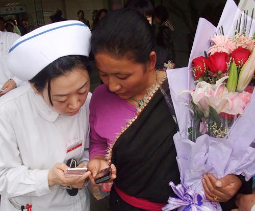 4月21日,西安交通大學(xué)第二附屬醫(yī)院骨二科副護(hù)士長李珂(左)把自己的電話號(hào)碼留給了出院返鄉(xiāng)的干措,以方便聯(lián)系。當(dāng)日下午,4名青海玉樹地震災(zāi)區(qū)傷員從西安交通大學(xué)第二附屬醫(yī)院傷愈出院,踏上返鄉(xiāng)之路。在首批送往西安救治的95名青海玉樹地震災(zāi)區(qū)傷員中,有40人被送至西安交通大學(xué)第二附屬醫(yī)院。這次出院的嘎瑪維斯、干措、藏尕、日多4人被送至醫(yī)院時(shí)均為軟組織損傷,經(jīng)過治療后明顯好轉(zhuǎn),達(dá)到出院標(biāo)準(zhǔn)。 新華社記者 李一博 攝