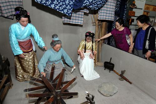 6月1日,幾位游客在參觀“元代棉紡織家黃道婆勞動(dòng)場(chǎng)景再現(xiàn)”。新華社記者 丁海濤 攝