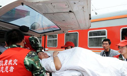6月1日,在西寧車站,列車員、鐵路青年志愿者將傷員抬上車。新華社記者 侯德強(qiáng) 攝