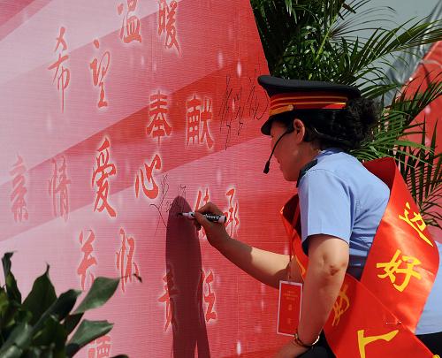 6月18日,入選“中國好人榜”的太原鐵路員工史改梅在愛心墻上寫下自己的名字。新華社記者 范敏達(dá) 攝