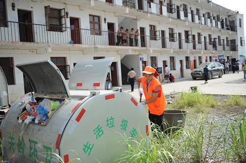 7月4日,清潔人員正在處理臨時(shí)安置點(diǎn)的生活垃圾。新華社記者 劉續(xù) 攝