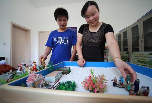 7月24日,南通一對母子在社區(qū)心理健康服務基地的“沙盤室”里體驗沙盤游戲心理療法。新華社發(fā)(黃哲 攝)