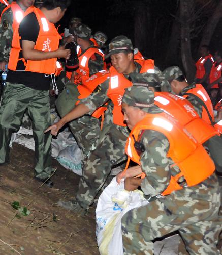 7月28日凌晨,武警官兵、解放軍戰(zhàn)士及吉林省干部群眾正在飲馬河堤防連夜加固堤壩。新華社記者齊海山攝