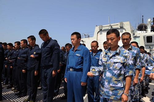 8月15日,正在出訪途中的中國海軍第五批護航編隊組織官兵在“廣州”艦后甲板莊嚴列隊默哀,悼念舟曲特大山洪泥石流遇難同胞。 新華社記者劉春暉攝