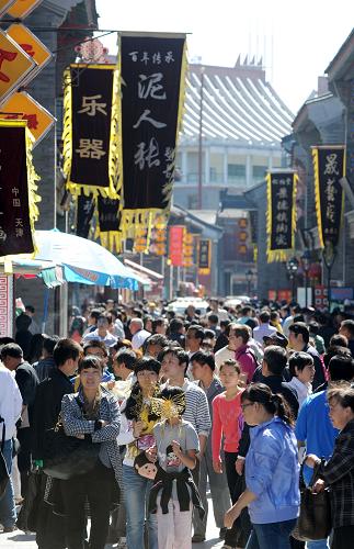 9月22日,游客們在天津古文化街游玩。當天,天津古文化街在中秋佳節(jié)之際推出逛古街看民俗活動,市民和游客在逛古文化街時,不僅能欣賞到戲曲表演和民俗手工藝品制作,還能現場參與制作中秋月餅,親身體驗民俗文化。新華社記者 岳月偉攝