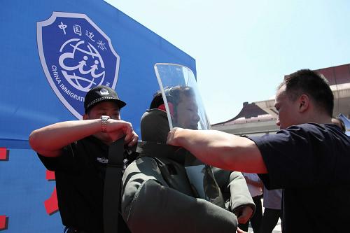 9月28日,珠海邊檢總站拱北站民警教導(dǎo)群眾穿防爆毯。 當(dāng)日,珠海邊檢總站通過(guò)“警用裝備展示區(qū)”“文字圖片展示區(qū)”“法律宣傳咨詢區(qū)”“警務(wù)技能演示區(qū)”四個(gè)展區(qū),向參觀群眾展示出入境邊防檢查工作內(nèi)容以及珠海邊檢60年歷史變遷。 新華社發(fā)(張金加 攝)