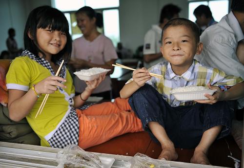 10月8日,安置區(qū)內(nèi)的一對姐弟正在吃午飯。新華社記者郭程攝