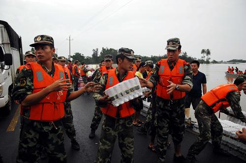 10月8日,武警官兵在萬寧市萬城鎮(zhèn)烏場村向船上搬運救災物資。新華社記者 侯建森 攝